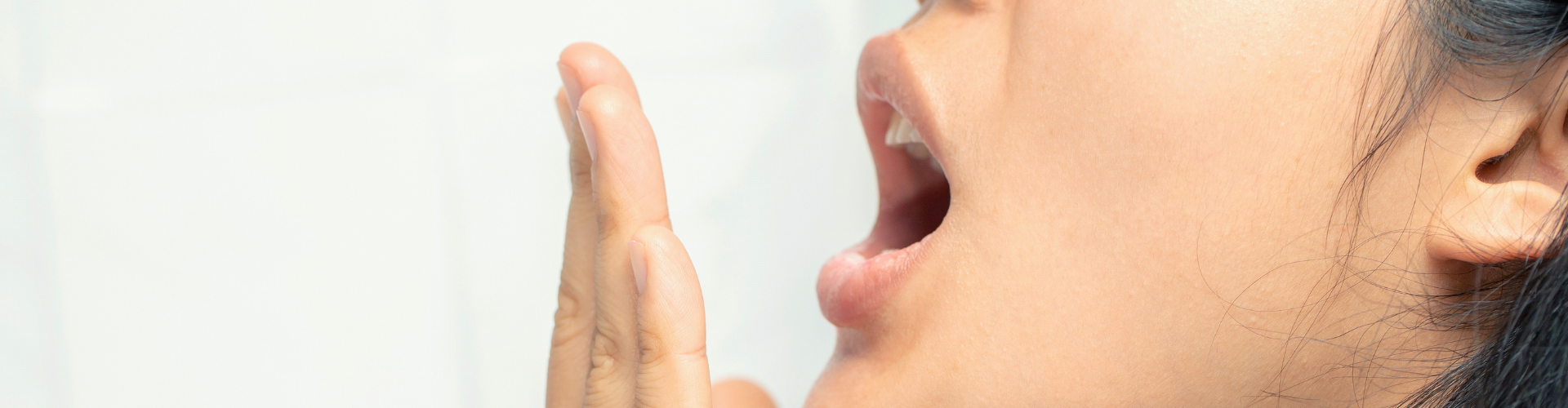 Woman blowing breath into her hand.